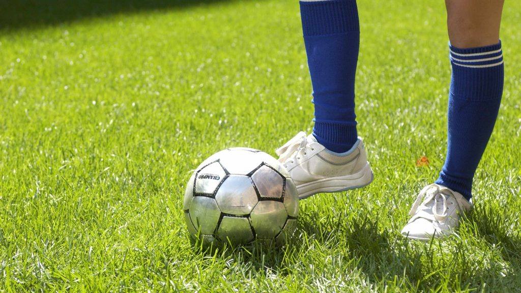 القدم والساق بجانب كرة القدم ؛ ركل القدم كرة القدم