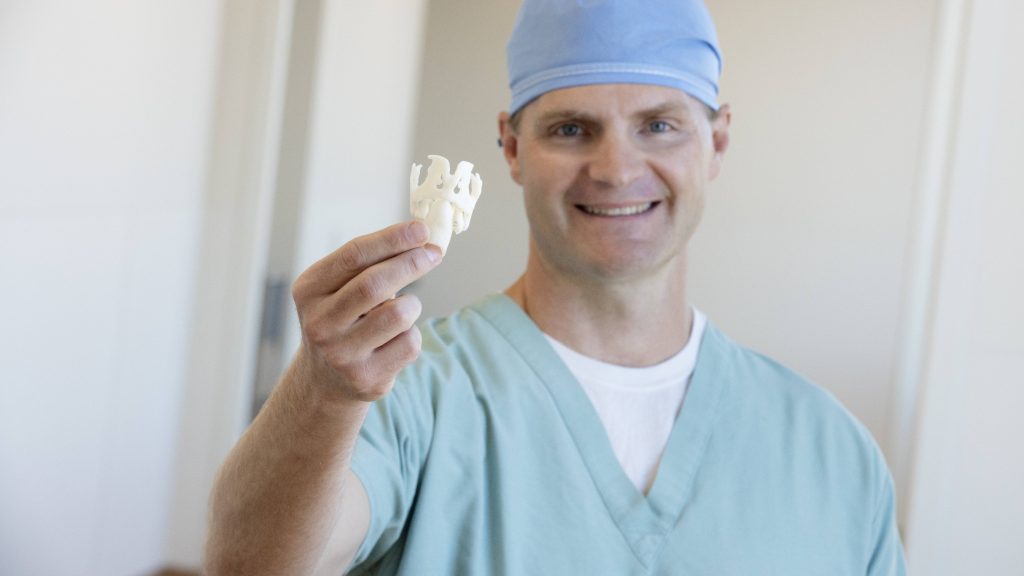 Dr. David Lott segurando uma laringe produzida por uma impressora 3D