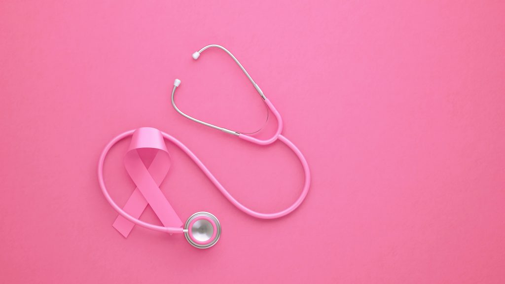 Estetoscópio rosa e fita rosa de conscientização sobre o câncer de mama em fundo rosa
