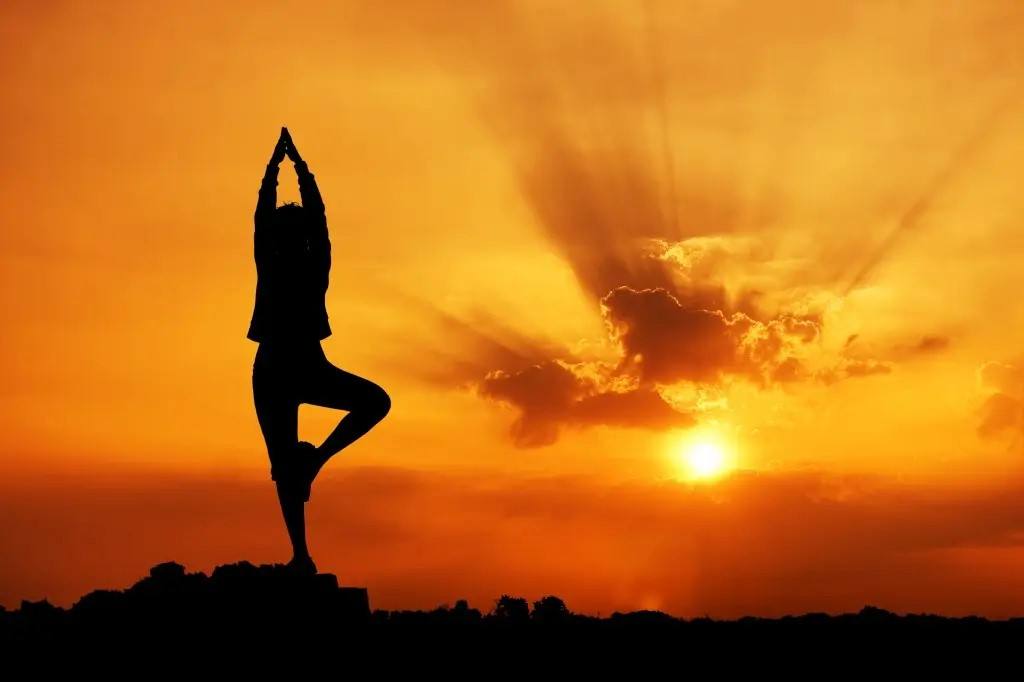 mulher-fazendo-yoga-ao ar livre-ao-pôr-do-sol