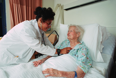 Nurse checking patient with a stethoscope