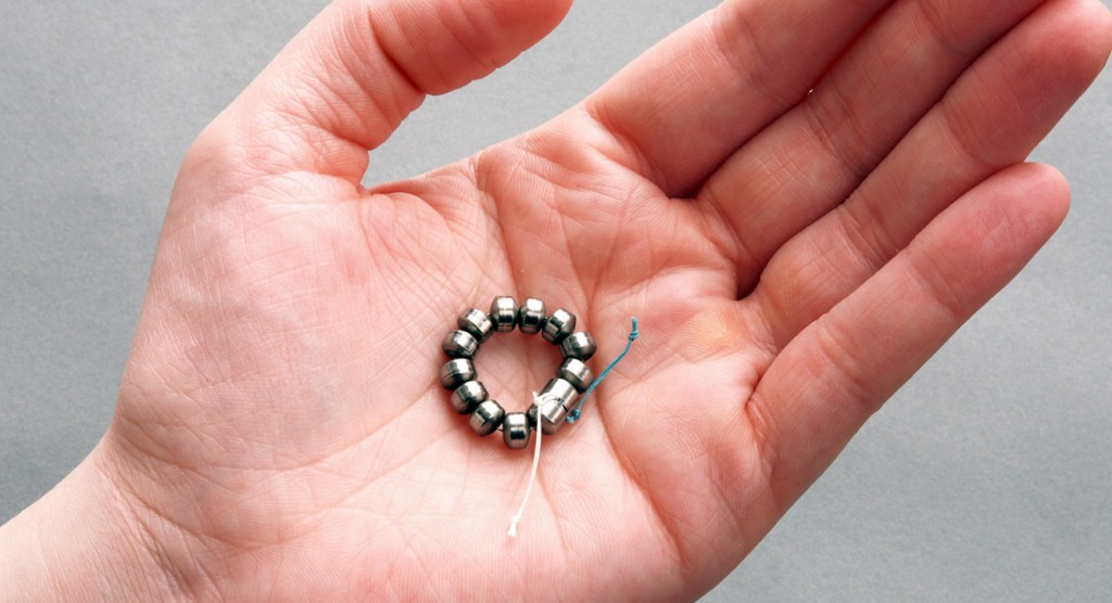 the ring of titanium beads held in the palm of someone's hand