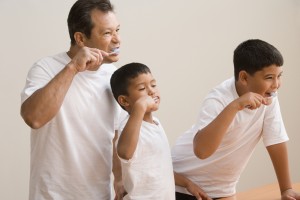 Father and sons brushing teeth