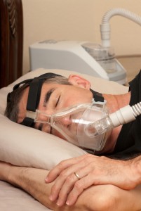 Man sleep with CPAP mask for sleep apnea.