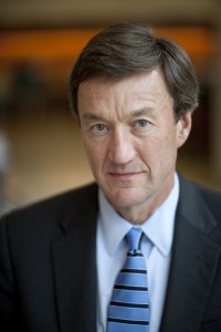 Mayo Clinic President and CEO, Dr. John Noseworthy in blue suit and striped tie