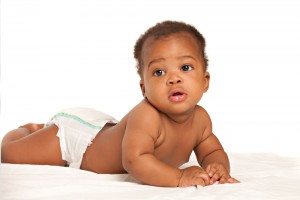 African American baby boy in diaper on white blanket