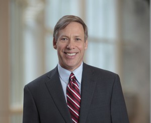Mayo Clinic CAO Jeff Bolton in a gray suit and red striped tie