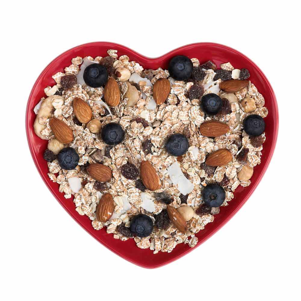 Heartshaped bowl of oatmeal, nuts and berries