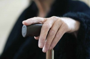 Elderly woman's hand on a cane.