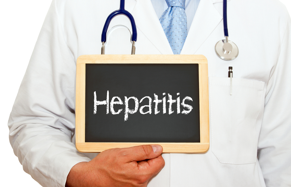 The word hepatitis written on a blackboard held by a doctor. 
