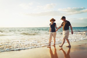 Una pareja conversa en la playa, agarrados de la mano
