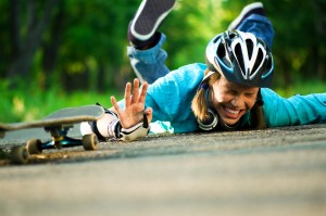 Young girl lying on ground from skateboard accident