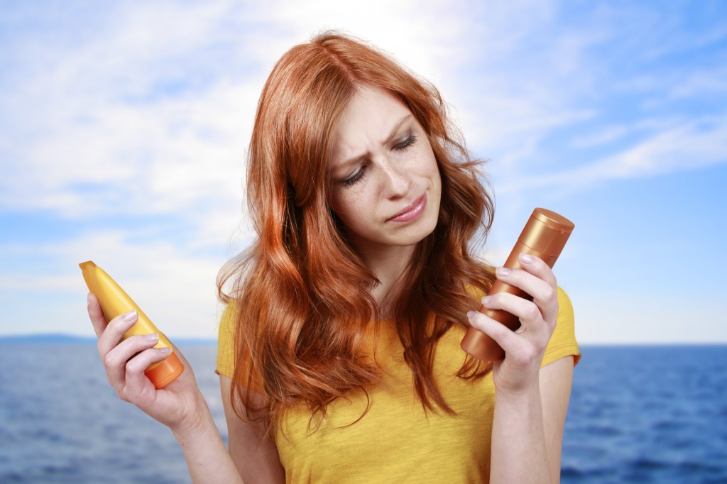 woman holding two bottles of sun screen or tanning lotion
