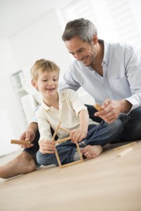 adult man playing building blocks game with child