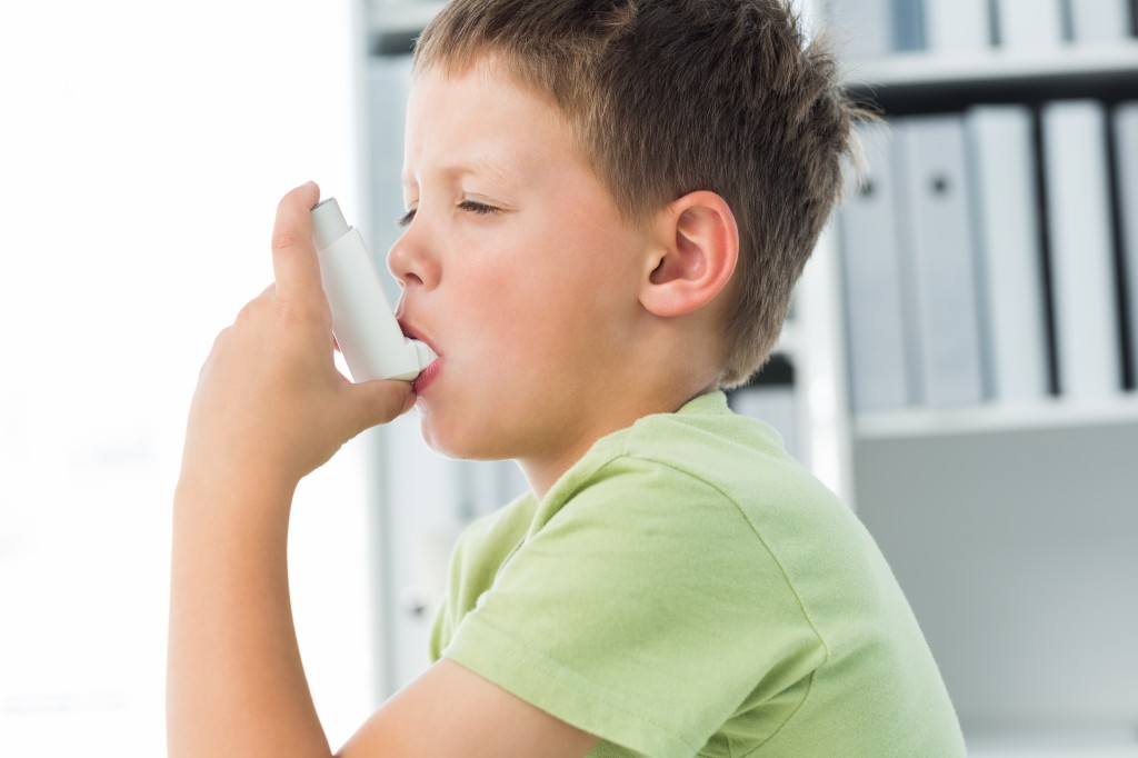 little boy using an asthma inhaler