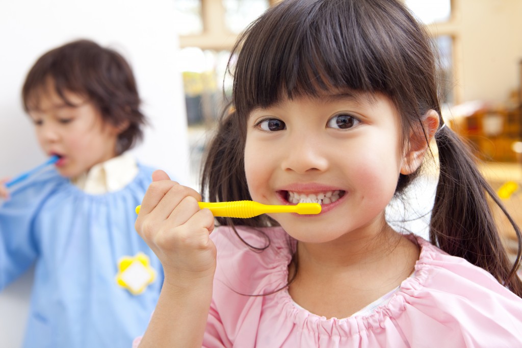 young girl brushing her teeth for good oral health