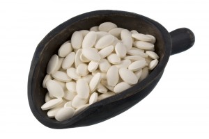 White dietary supplements on a rustic wooden scoop