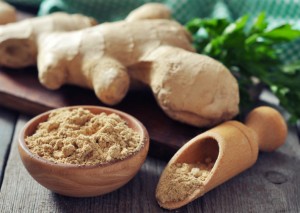 fresh ginger root and ground ginger spice on wooden background