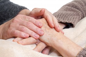 caregiver holding patient's hands