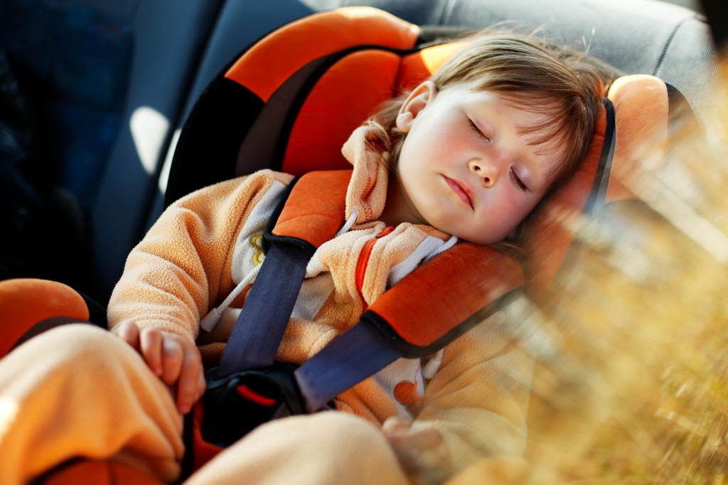 young child in car seat sleeping in car
