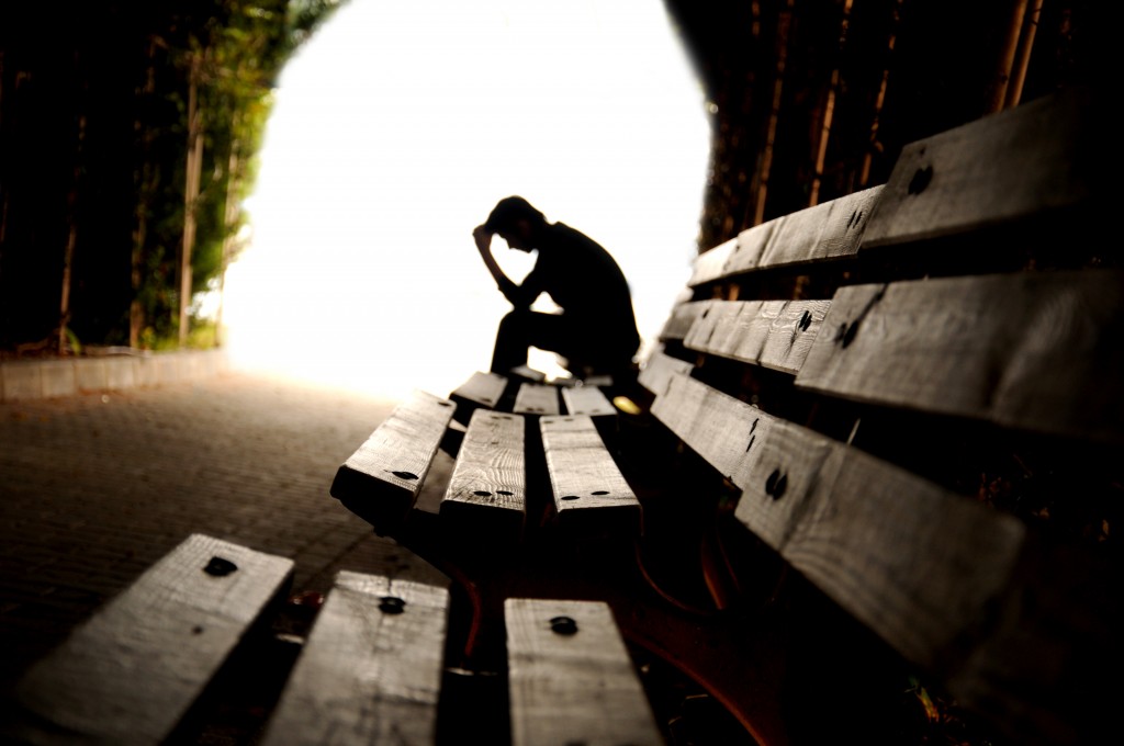 lonely man sitting on a park bench