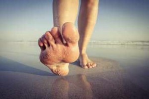 una persona camina descalza por la playa