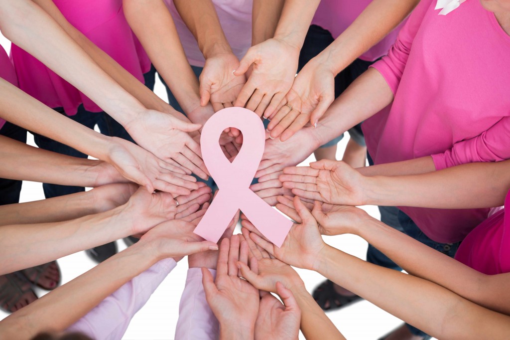 women's hands in a circle with a pink ribbon for breast cancer awareness