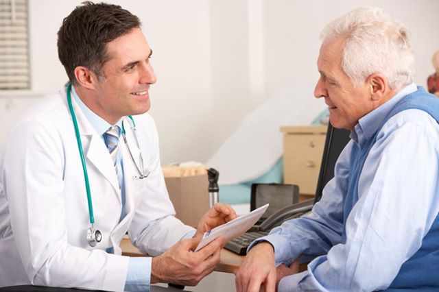 a male doctor talking with an elderly male patient