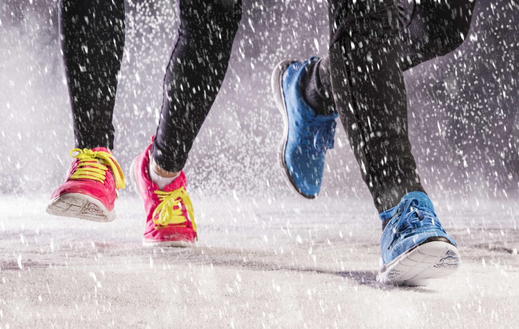 woman and man are running during winter training outside in cold snow weather.