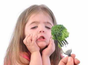 Una niña pone cara de disgusto frente al brócoli