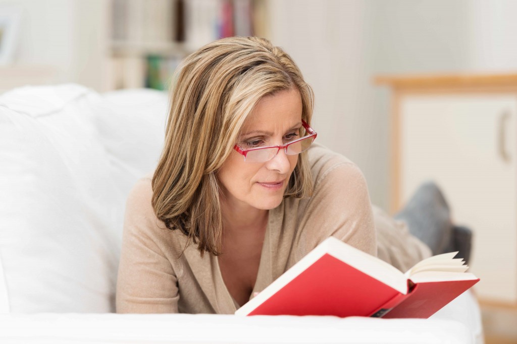 woman with glasses reading a book, vision