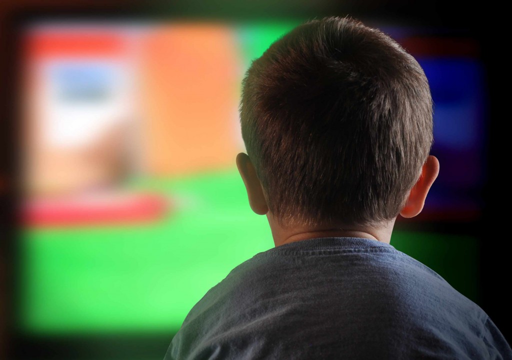 little boy staring at electric , digital television screen