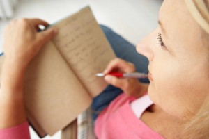woman with pen writing in journal, feelings
