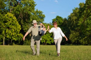 middle aged couple walking and exercising, having fun with child