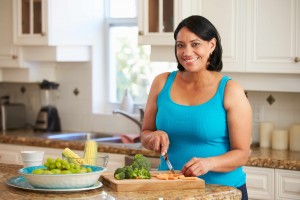 woman in kitchen cutting up healthy vegetables