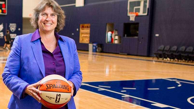 Minnesota Lynx basketball coach Nancy Cummings standing on a basketball court, holding a basketball