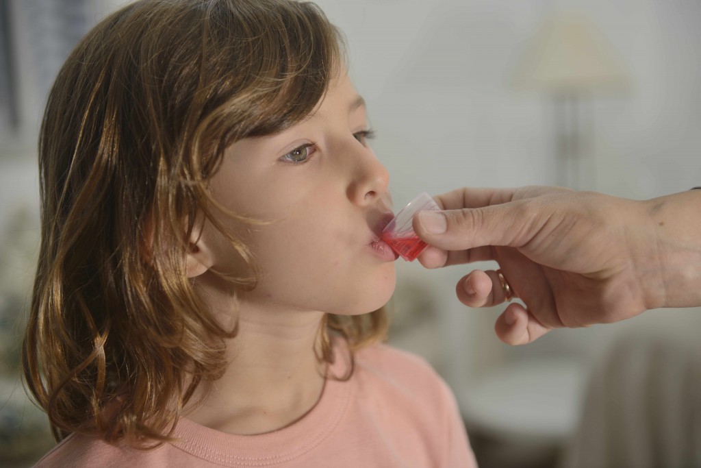 little girl taking medicine, antibiotic or cough syrup