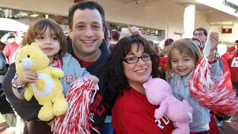 Scott Borden Family photo, wife and little girls holding stuffed animals and pom-poms