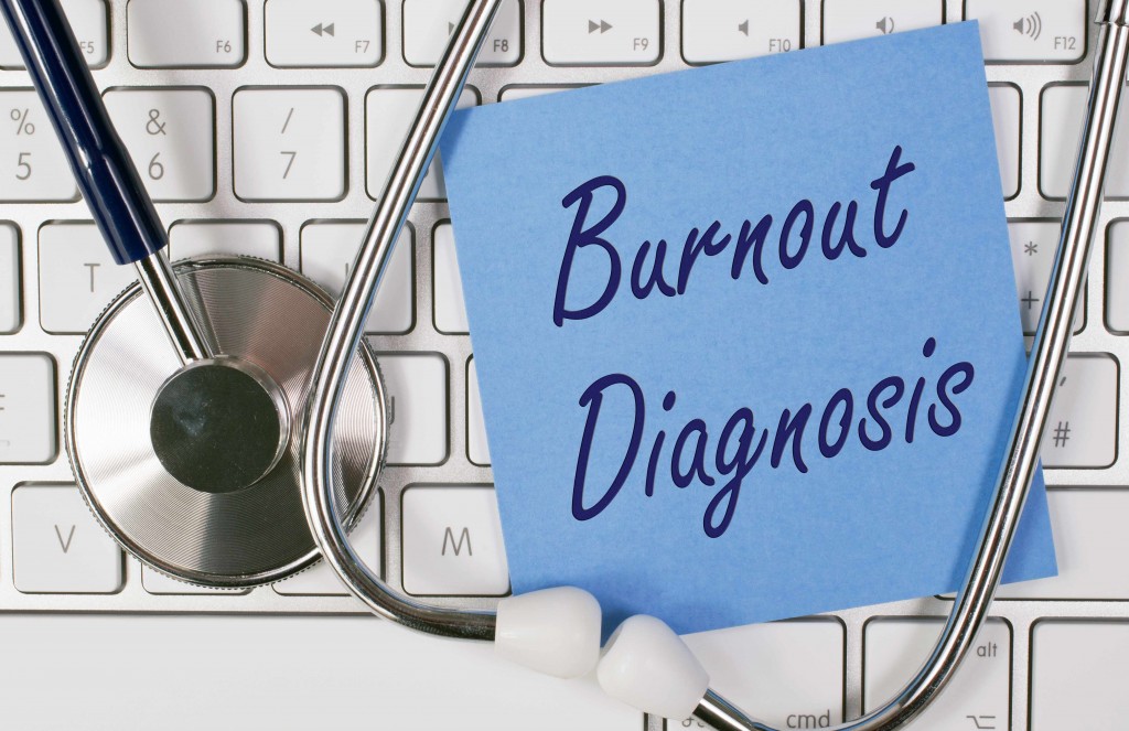 Una nota que dice “diagnóstico de desgaste profesional” aparece sobre el teclado junto a un estetoscopio