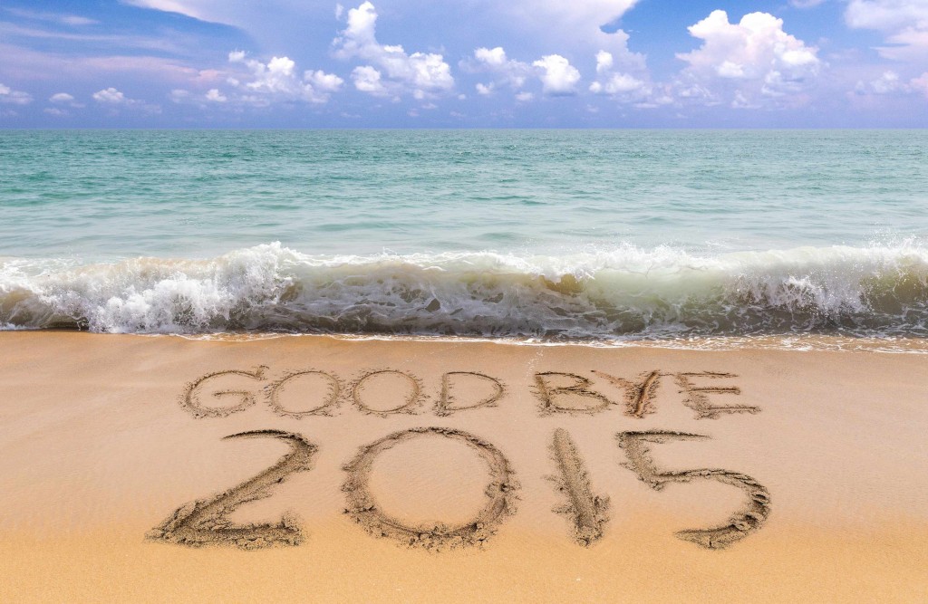 goodbye 2015 written in beach sand with waves in background