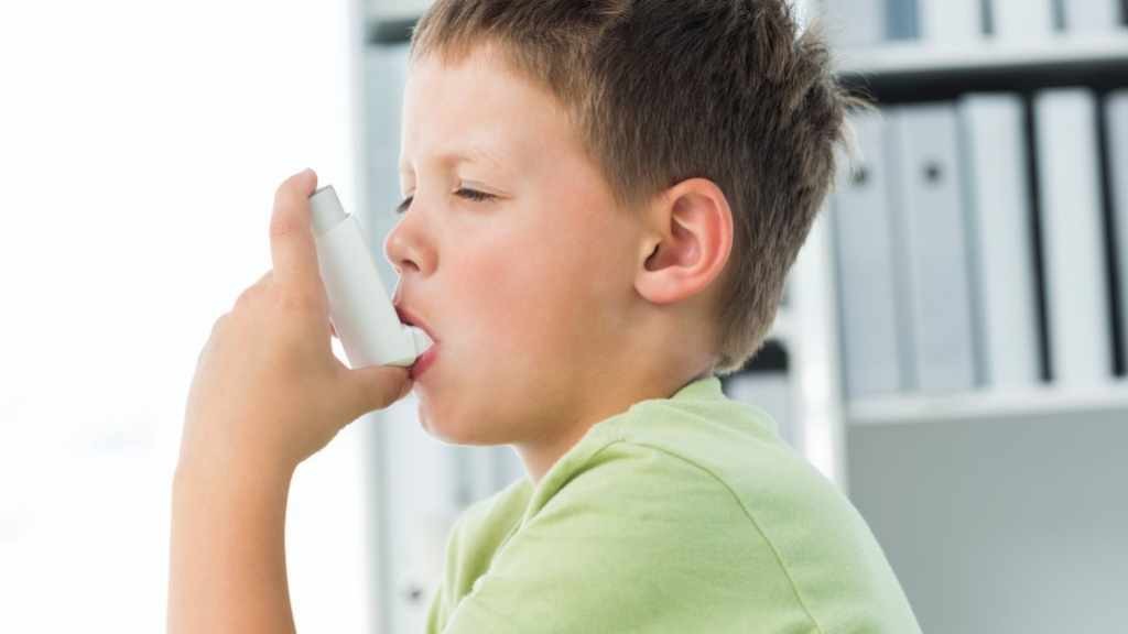 young boy with inhaler for asthma 16x9
