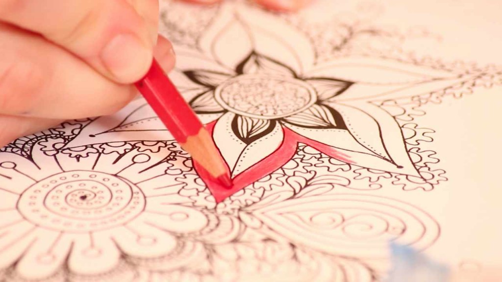 person coloring an image with a red pencil 
