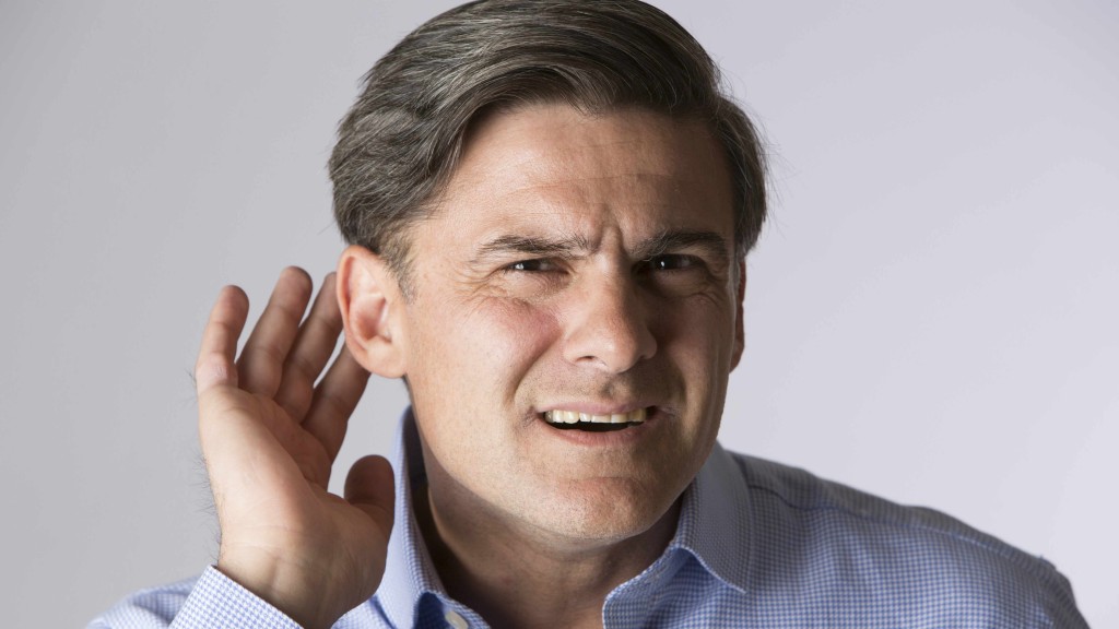 Un hombre coloca su mano en forma de cuenco sobre el oído para intentar escuchar porque ha perdido la audición