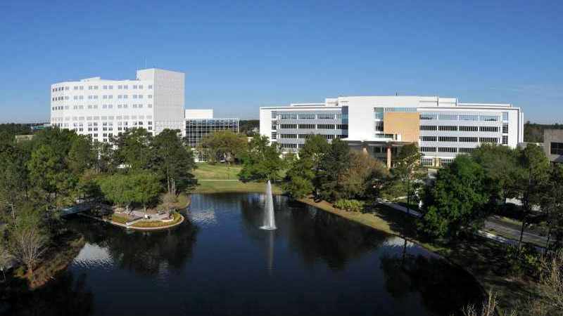 Vista ampliada del recinto médico de Mayo Clinic en Florida, con cielo azul y agua en el trasfondo