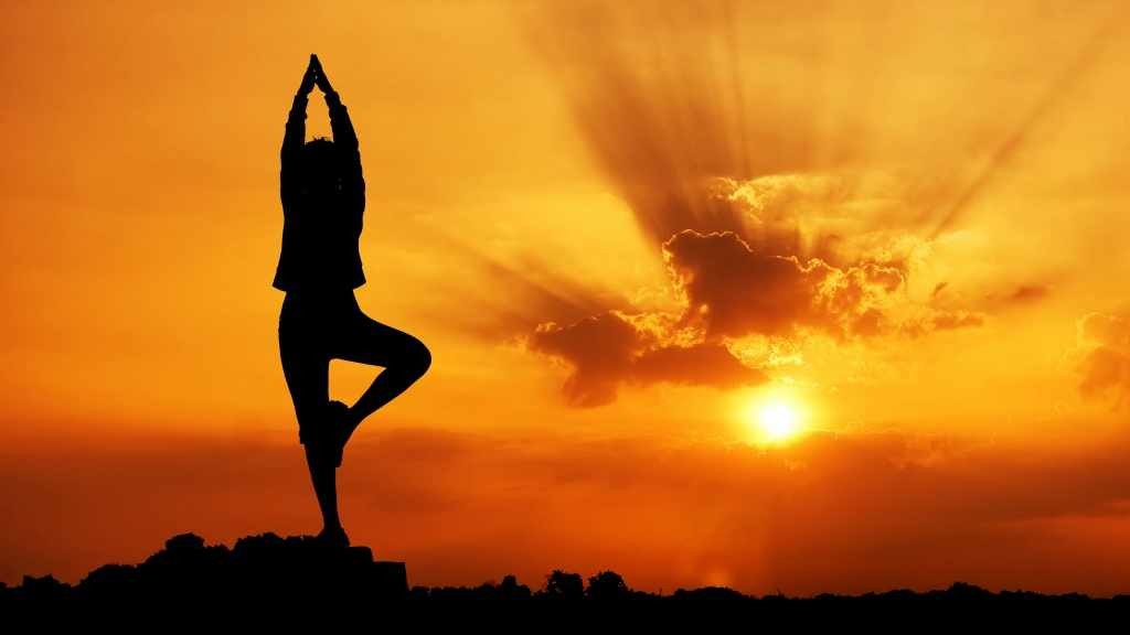 mujer haciendo yoga, al aire libre al atardecer