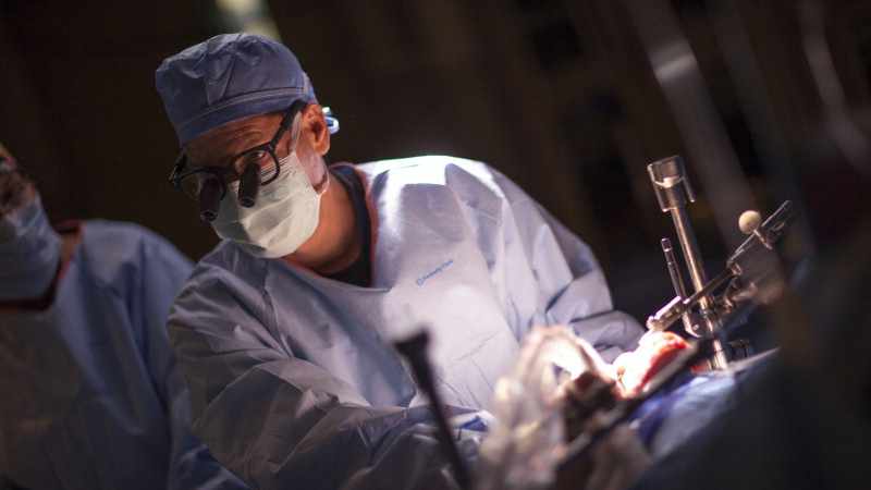 a surgeon in operating room performing a lung transplant