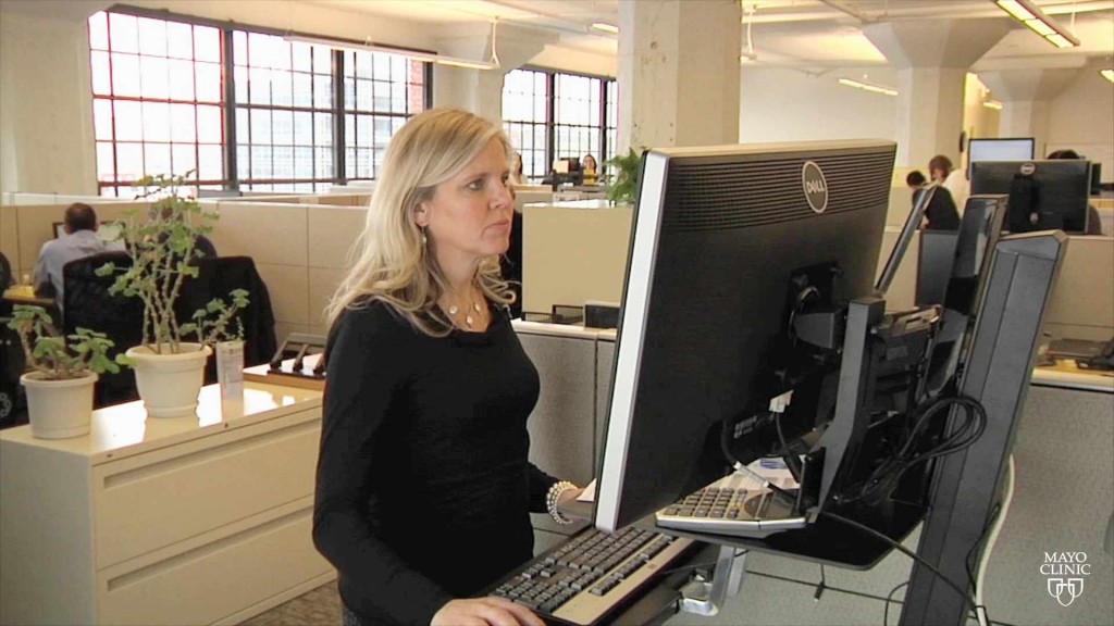 a woman working at a standing desk 