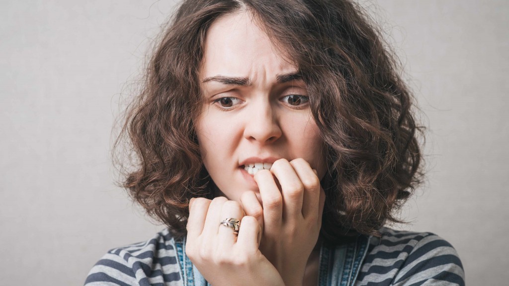 an anxious or nervous woman biting her nails and looking worried