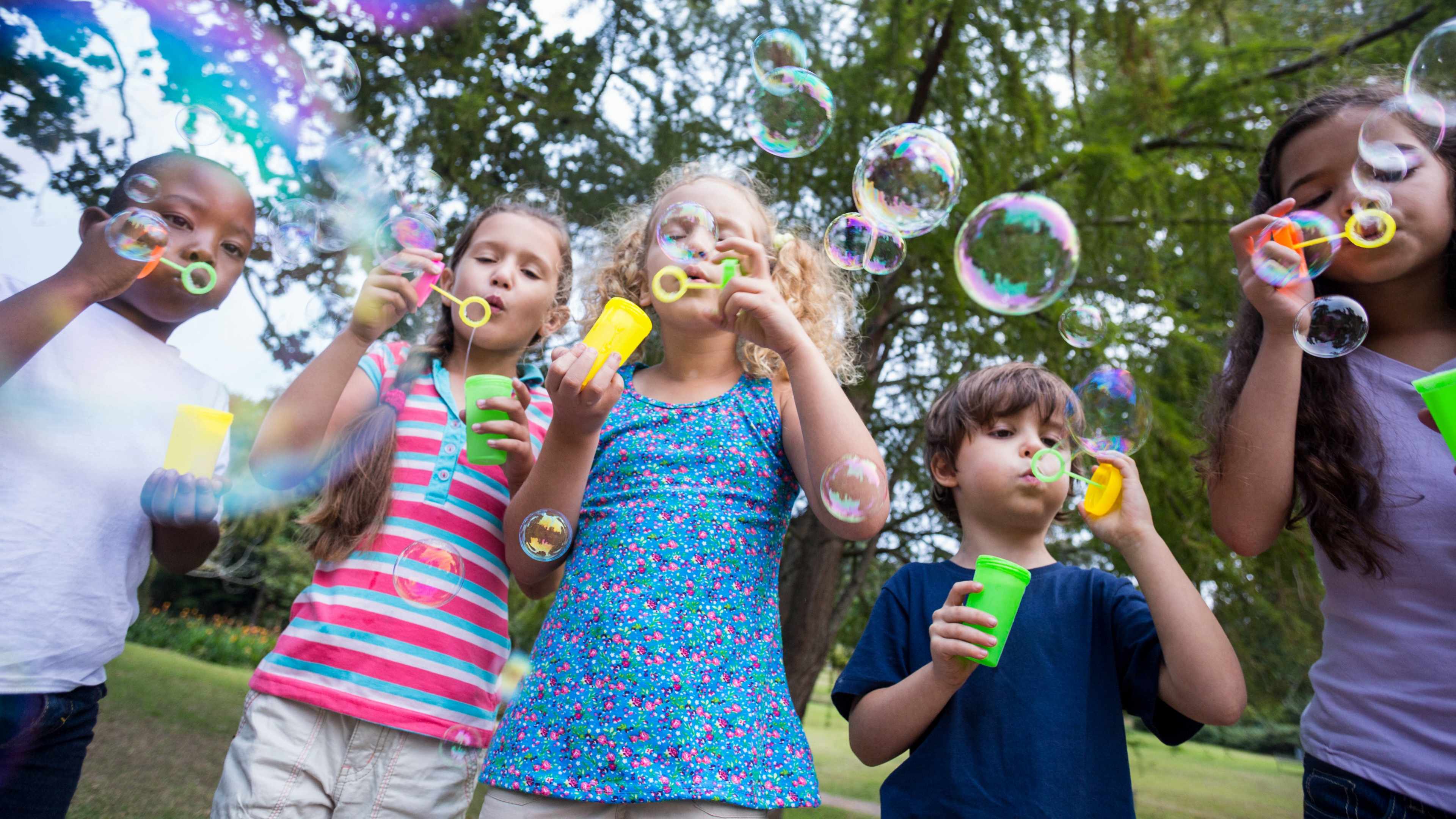 children with positive energy playing and having fun blowing bubbles