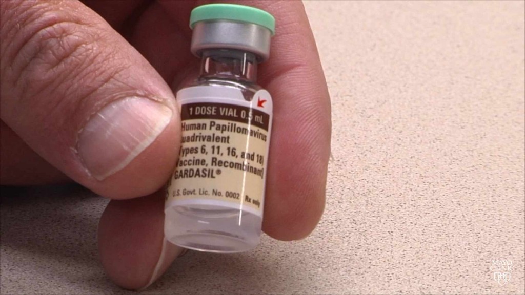 fingers holding a bottle of human papillomavirus (HPV) vaccine